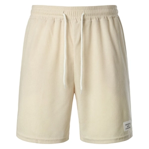 Detailed texture of beige corduroy shorts featuring elastic drawstring waist and sport label