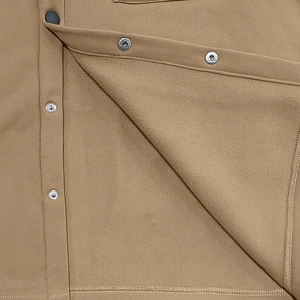 Détail de la veste tactique kaki avec boutons-pression métalliques et coutures renforcées