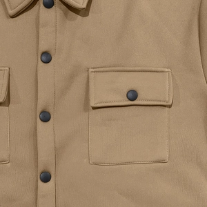 Détail d'une veste tactique kaki avec boutons-pression noirs et poches à rabat