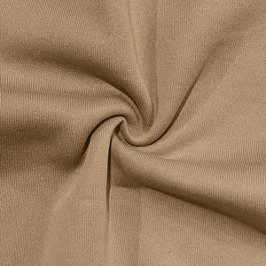 Détail du tissu en maille marron camel avec texture côtelée et drapé souple