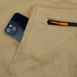 Détail du pantalon cargo en polaire kaki avec grande poche et tirette orange du zip