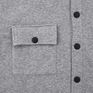 Détail macro du tissu gris doublé polaire et des boutons-pression noir mat de la veste
