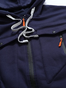Détail de la veste à capuche bleu marine avec cordon de zip orange vif