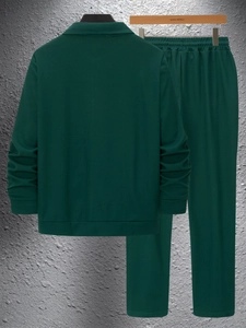 Detailed waffle knit texture of dark green two-piece men's casual jacket and trousers set
