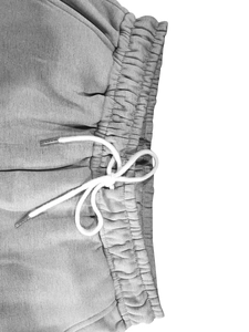 Détail du pantalon en polaire gris avec taille élastique et cordons de serrage blancs ronds