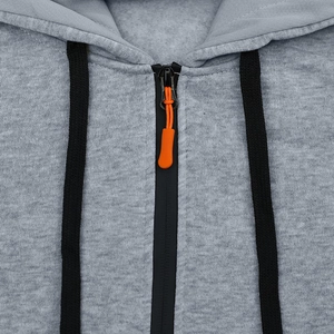 Gros plan sur le sweat à capuche gris avec fermeture éclair noire et tirette orange vif