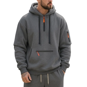 Close-up of heavy dark grey men hoodie with orange zipper pulls and multi-pocket design