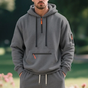 Detail of dark grey heavyweight hoodie with orange zipper puller and kangaroo pocket