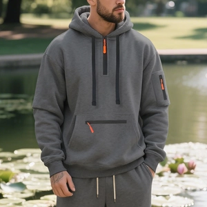 Detail of dark grey heavyweight fleece hoodie with 1/4 zip and orange contrast puller