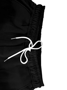 Détail du pantalon tactique noir avec taille élastique et cordon de serrage blanc épais