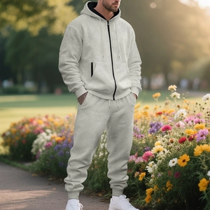Detail of light gray zip-up fleece hoodie and joggers set with black contrast trim
