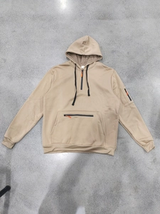 Macro detail of khaki hoodie with orange zipper pulls and tactical sleeve pocket