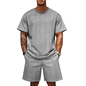 Detail of grey knitted men's summer set featuring intricate cable knit texture and relaxed fit