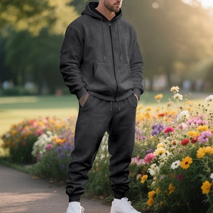 Men's dark grey thermal zip hoodie and joggers set shown in an outdoor garden setting