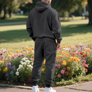 Rear view of dark grey heavy fleece hoodie and joggers set in a sunny park setting