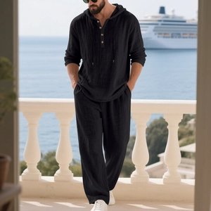 Close-up of black linen hooded Henley shirt and pants set on a scenic seaside balcony