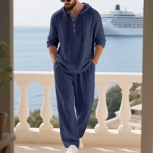 Men's navy linen resort set featuring hooded Henry shirt and trousers on cruise balcony