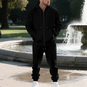 Men's heavyweight black fleece hoodie and jogger set shown in an outdoor park setting