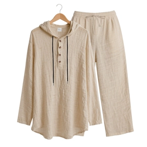 Detail of light beige men's linen set showing drawstring hood and buttoned Henley neck