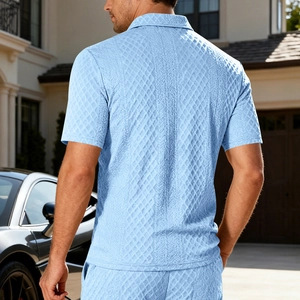 Dettaglio di una polo azzurra con trama a rombi indossata da un modello uomo