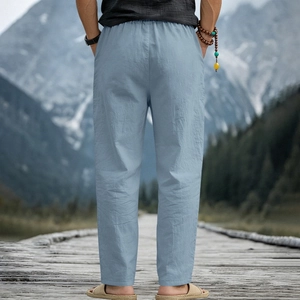Rear view of men's casual light blue linen trousers with elastic drawstring waist on a bridge