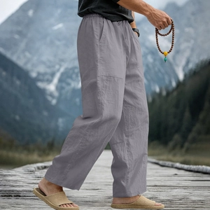 Detail of grey linen trousers featuring elastic waist and breathable fabric texture