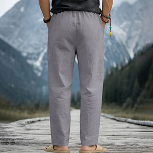 Linen casual pants for men with drawstring waist styled on a scenic lakeside boardwalk