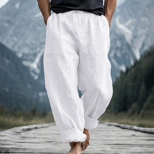 Detail of white linen beach pants showing drawstring waist and side cargo pocket design