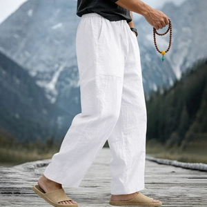 Close-up of men's white linen trousers with natural texture and elastic waist detail