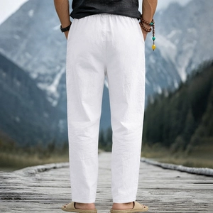 Detail of white linen trousers with elastic waist on a scenic outdoor boardwalk