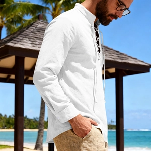 Detail of white cotton linen beach shirt featuring lace-up V-neck and stand collar design