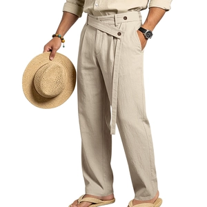Detail of beige linen trousers featuring a drawstring waist and brown button accents