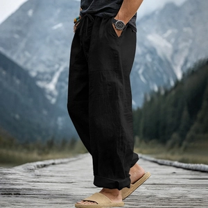 Outdoor view of men's black linen wide-leg pants with drawstring and side pockets