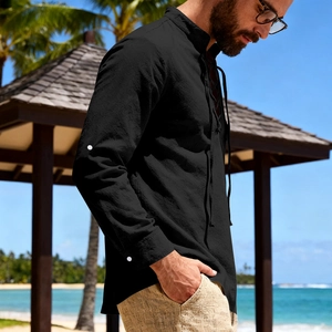 Detail of black cotton linen Henley shirt with lace-up collar for men on the beach
