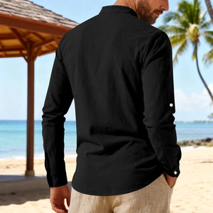 Detail of black cotton linen shirt with roll-up sleeves on a sunny beach resort