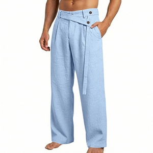 Detail of light blue linen trousers showing high-waisted button design and fabric texture