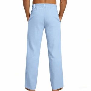 Detail of light blue linen trousers showing elastic waistband and natural fiber texture