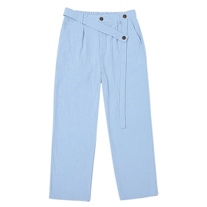 Detailed view of light blue linen trousers with high waist design and three brown buttons