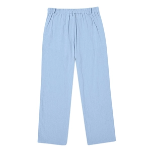 Macro detail of light blue linen trousers showing high-quality fabric texture and elastic waist