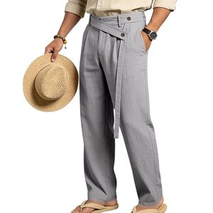 Detail of blue linen casual trousers with wrap-around long belt and brown button