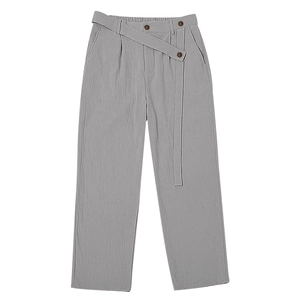 Detail view of grey linen trousers featuring a high-waisted elastic band with buttons