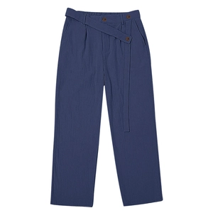 Detailed texture of dark blue linen trousers with waist belt and button closure