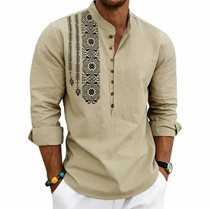Close-up of geometric ethnic embroidery and wooden buttons on a khaki linen henley shirt