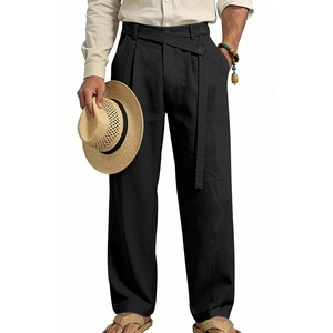 Detail of black linen trousers showing natural fabric texture and pleated waist with belt