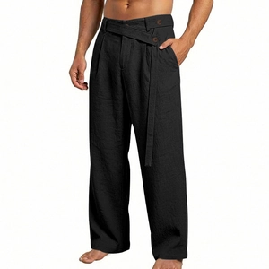 Detail of men's linen-texture trousers featuring asymmetric waist buckle and brown button