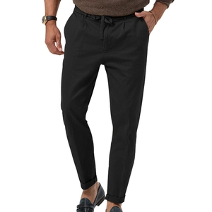 Detail of men's black drawstring waist trousers with a slim fit and rolled cuffs
