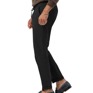 Detail of men's casual black trousers showing elastic drawstring waist and cuffed hem