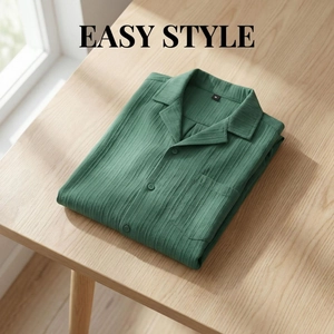 Detail of green short-sleeved Cuban collar shirt featuring vertical striped texture and pocket