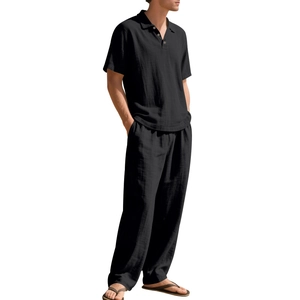 Detail van zwart linnen poloshirt en bijpassende losse broek met gestructureerde stof