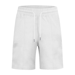 Detailed view of white waffle knit shorts featuring elastic drawstring waist and metal tips